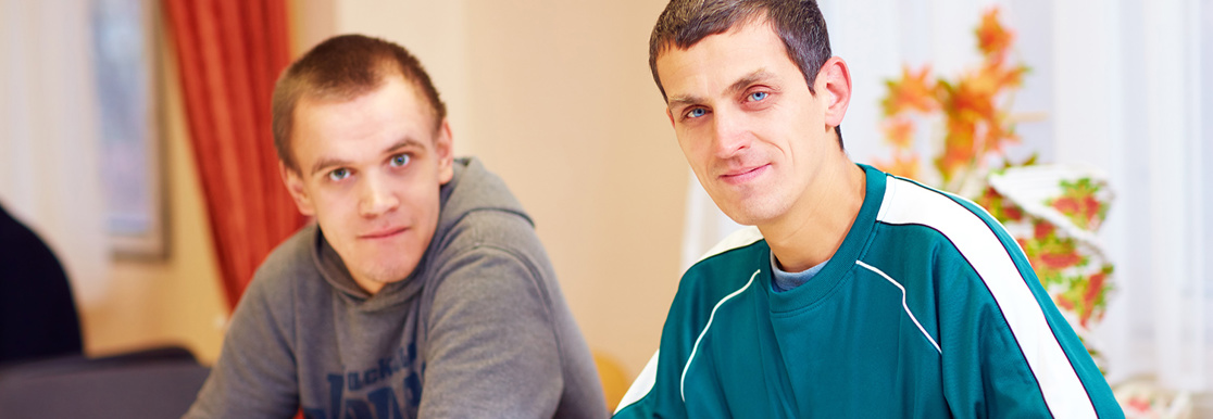 Two people sitting at a table looking at the camera
