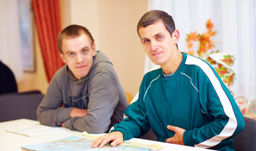 Two people sitting at a table looking at the camera